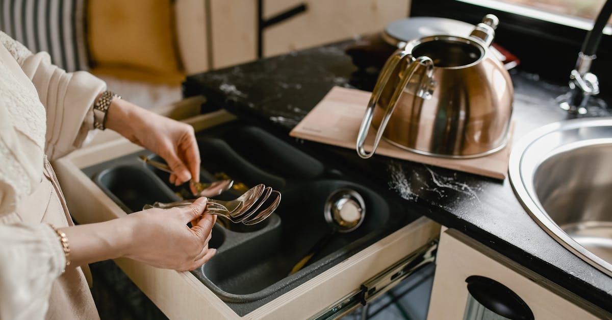 a person efficiently organizes silverware in a minimalist kitchen setting