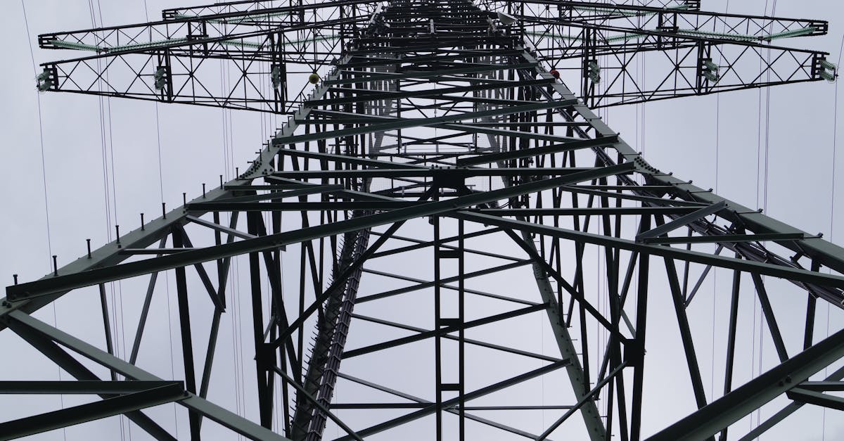 close up low angle view of a metal electricity pylon against a cloudy sky